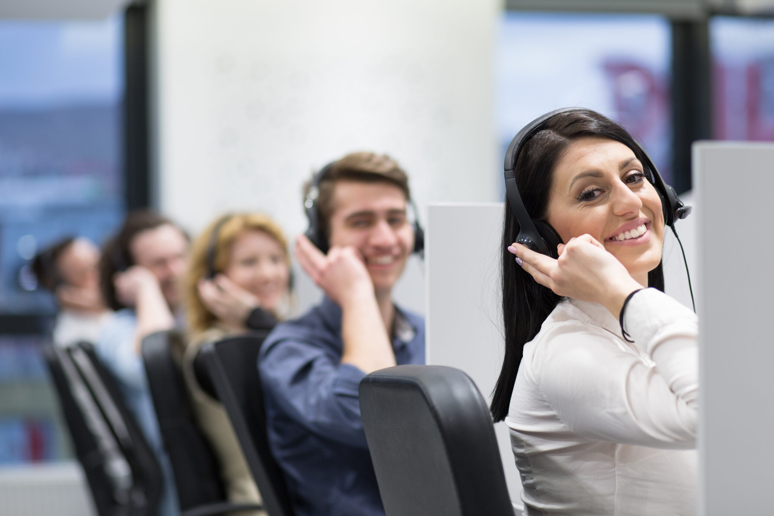 Call center operators group of young business people with headset working and giving support to customers in a call center office